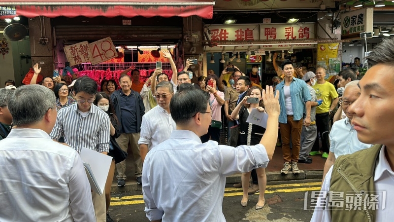 有市民在李家超到场时在马路旁欢呼，夹道欢迎特首。