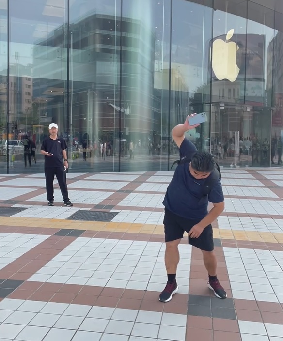 刘金在苹果店外反复把其iPhone掷落地。影片截图