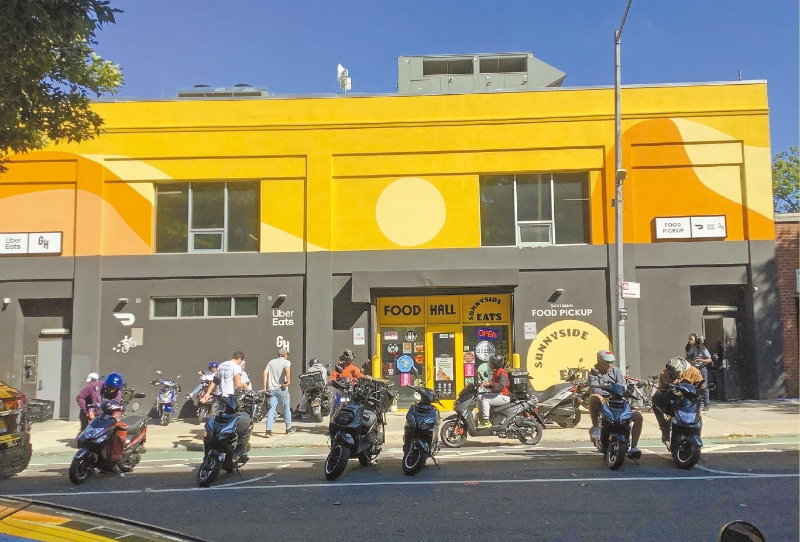 CloudKitchens位于皇后区长岛市的厨房据点门前，很多外卖员在等餐。