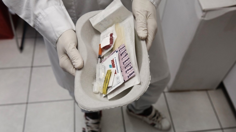 医护人员展示装有注射器、胶布和消毒绵片的吸毒工具包。 路透社