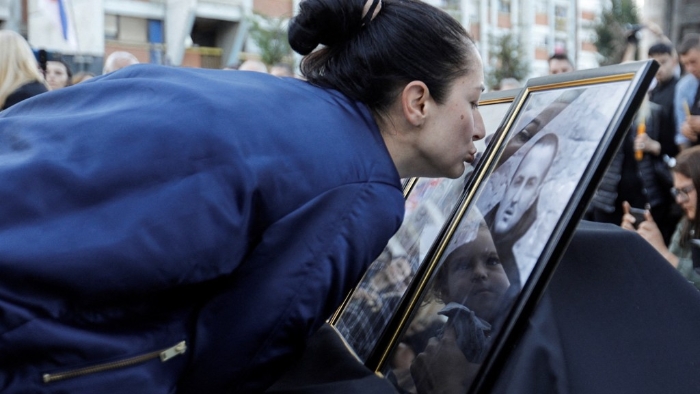 一名女子在悼念活动中亲吻遗照。