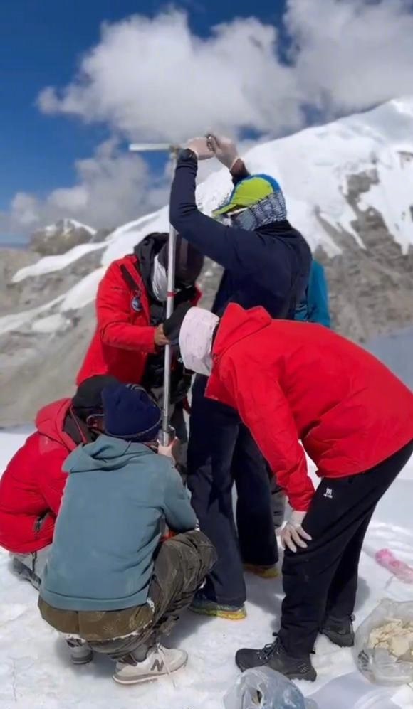 科考队员在山顶探集冰芯数据。