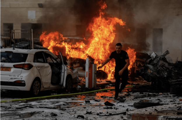 2023 年 10 月 7 日,以色列阿什凯隆,火箭从加萨地带发射后,一名男子在经历轰炸的道路上奔跑 2023 年 10 月 7 日,以色列阿什凯隆,火箭从加萨地带发射后,一名男子在经历轰炸的道路上奔跑