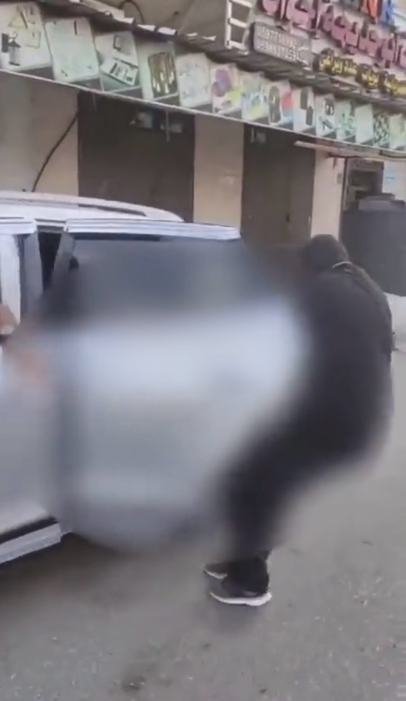 武装份子从车上拖出疑似以军尸体。 武装份子从车上拖出疑似以军尸体。