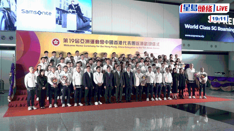 运动员凯旋回港,在机场与众嘉宾合照。直播截图 运动员凯旋回港,在机场与众嘉宾合照。直播截图