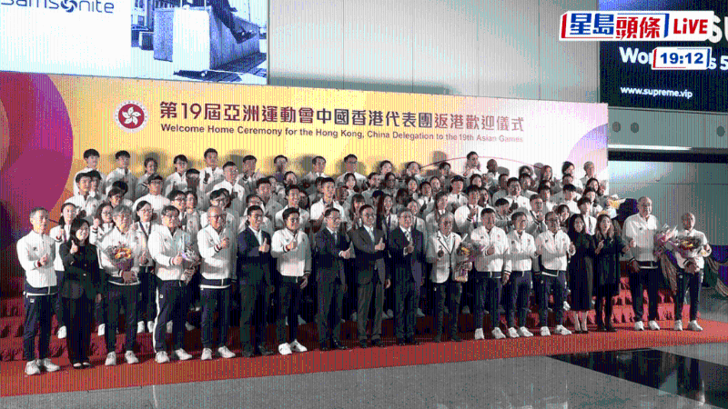 运动员凯旋回港,在机场与众嘉宾合照。 直播截图 运动员凯旋回港,在机场与众嘉宾合照。 直播截图