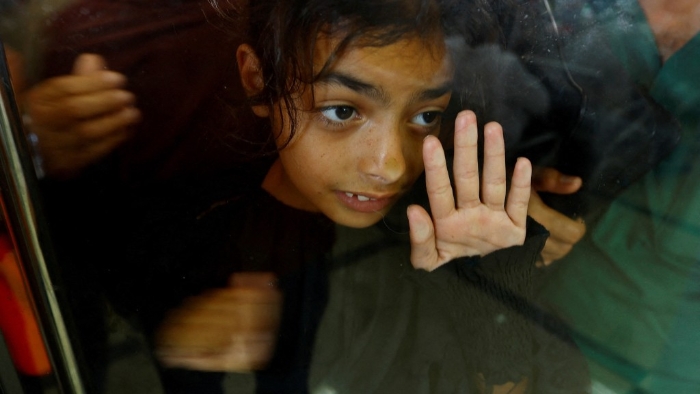 等候过境到埃及的巴勒斯坦小孩透过玻璃往外看。