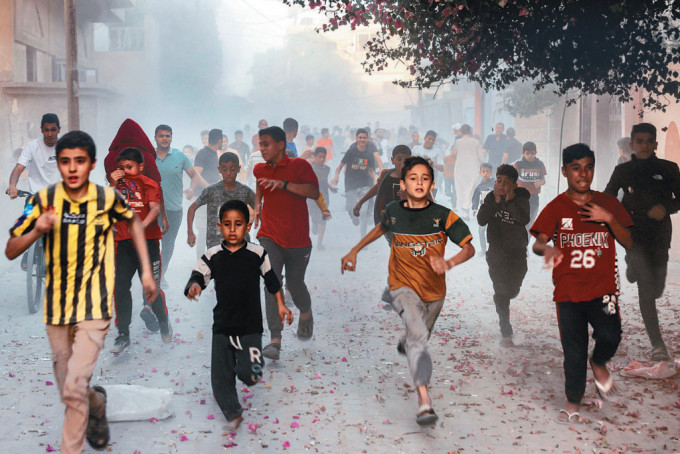 加沙南部拉法市一群巴勒斯坦儿童周一在街上奔跑，逃避以色列轰炸。
