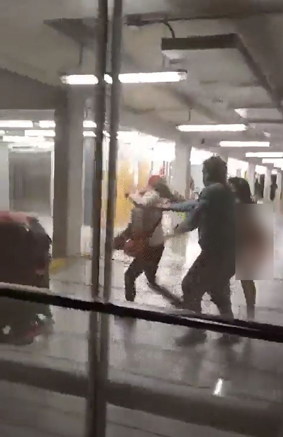 裸女情绪失控拉扯路过旅客头发。影片截图