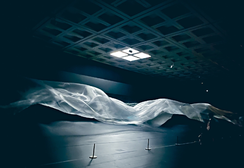 《Liminal Air - Time》呈现的黑暗与光亮，布幔轻浮半空的动态，予人沉浸于另一时空的感觉。