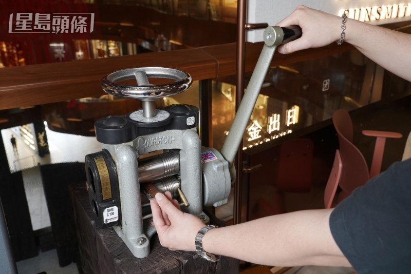 以冲压工艺技术将图案刻印在银牌上。