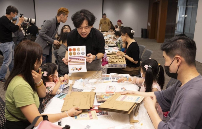 工作人员在古乐器亲子工作坊上向家长及小朋友讲解制作方式。 工作人员在古乐器亲子工作坊上向家长及小朋友讲解制作方式。