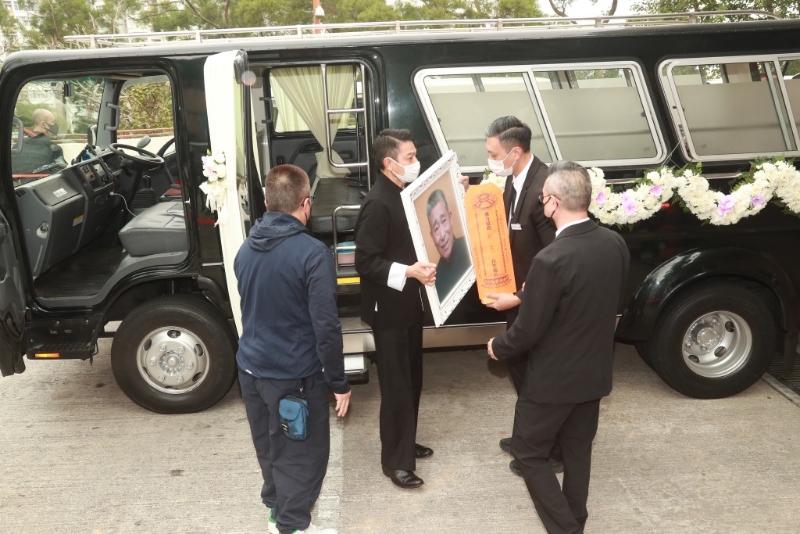 刘德华与胞弟站在灵车旁听从工作人员的指示。 刘德华与胞弟站在灵车旁听从工作人员的指示。