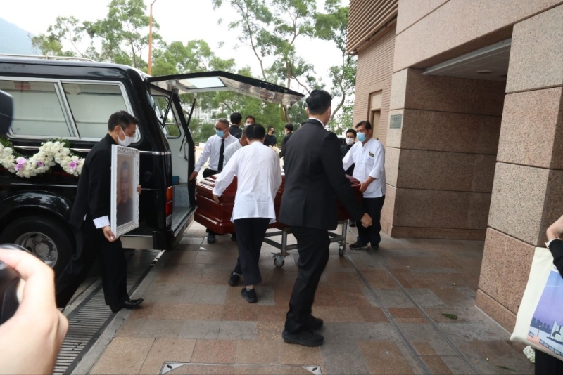 刘德华在工作人员护送下从灵车步往礼堂。 刘德华在工作人员护送下从灵车步往礼堂。
