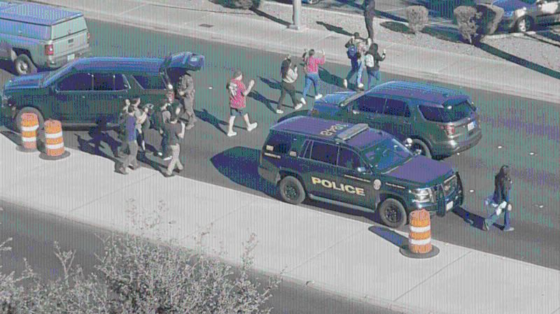 在警员指示下，师生举手步出校园。 路透社