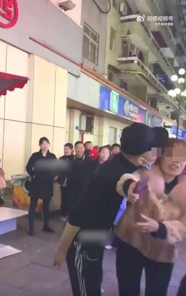 大妈冷不防被男档主吻了脸。网图