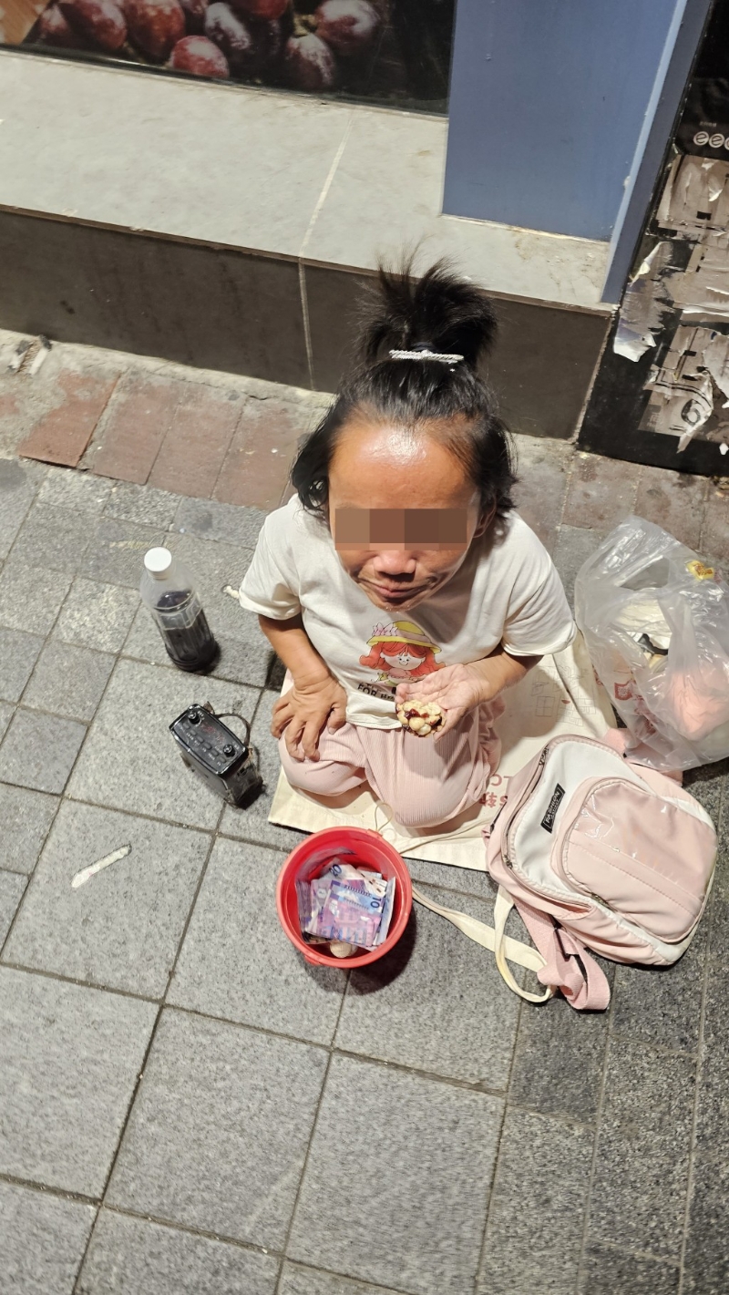 佐敦有女侏儒跪下讨钱,状甚可怜。 徐裕民摄 佐敦有女侏儒跪下讨钱,状甚可怜。 徐裕民摄