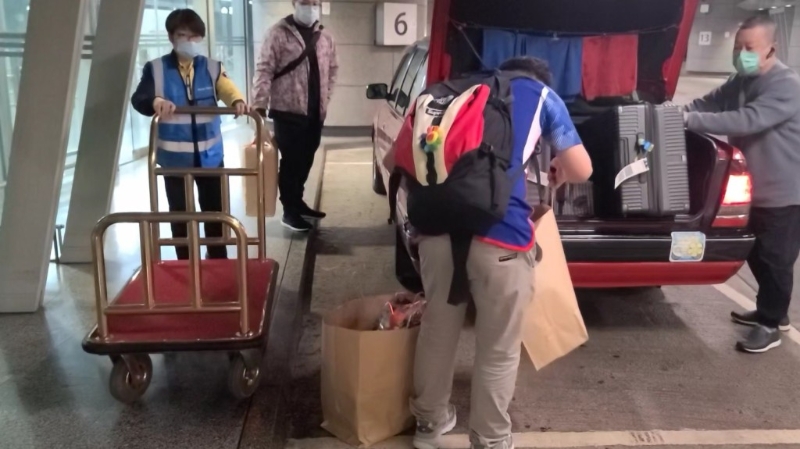 职员会等待旅客将行李搬上的士后收回。