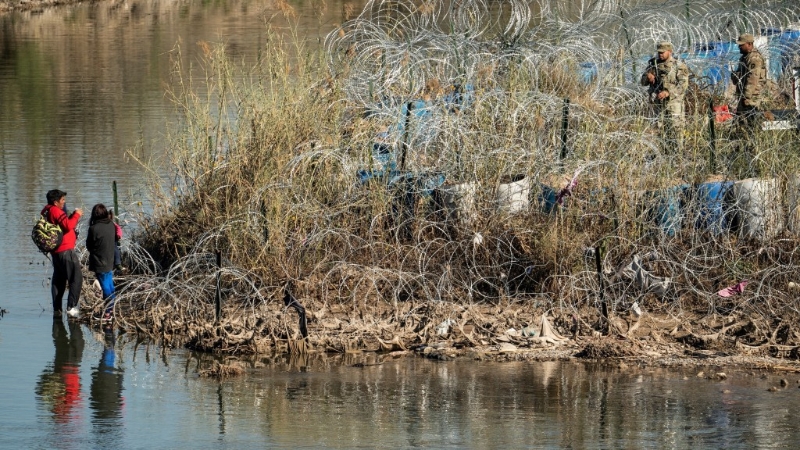 难民家庭从墨西哥穿越得克萨斯州格兰德河后,与美国国民警卫队成员交谈。 路透社 难民家庭从墨西哥穿越得克萨斯州格兰德河后,与美国国民警卫队成员交谈。 路透社