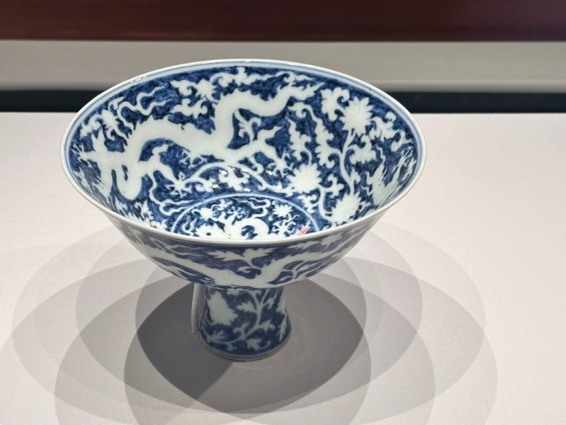 青花地留白龙穿花纹高足碗，「青花留白」的绘制技巧繁复，类似技巧的瓷器数量稀少。