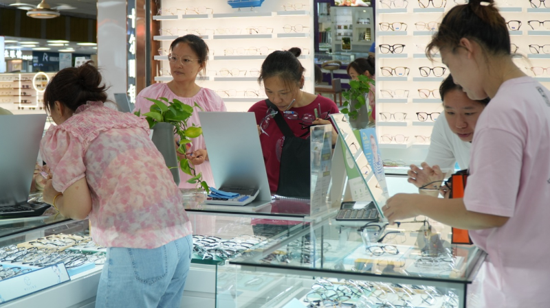 眼镜城里挑选眼镜的顾客