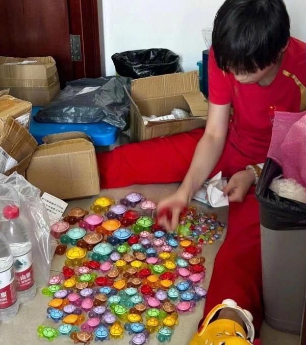 全红婵日前公开自己的收藏,见到她身穿国家队制服和黄色拖鞋,坐在地上排列大小不一、五颜六色的龟玩具。 全红婵日前公开自己的收藏,见到她身穿国家队制服和黄色拖鞋,坐在地上排列大小不一、五颜六色的龟玩具。