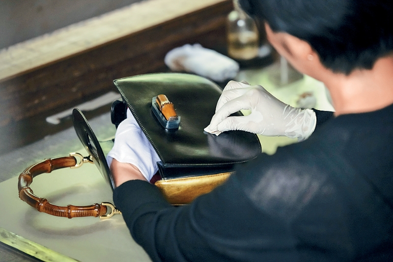 漆绘大师庆次爱运用传统琉球漆艺,将金箔融入多层彩漆,并将之绘于手袋上。 漆绘大师庆次爱运用传统琉球漆艺,将金箔融入多层彩漆,并将之绘于手袋上。