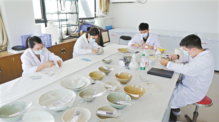 文物工作者在细心修补瓷器。