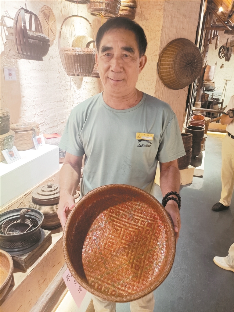 阳江闸坡渔家文化展览馆馆长谭国良展示渔家斗笠,斗笠可盛水而不漏。