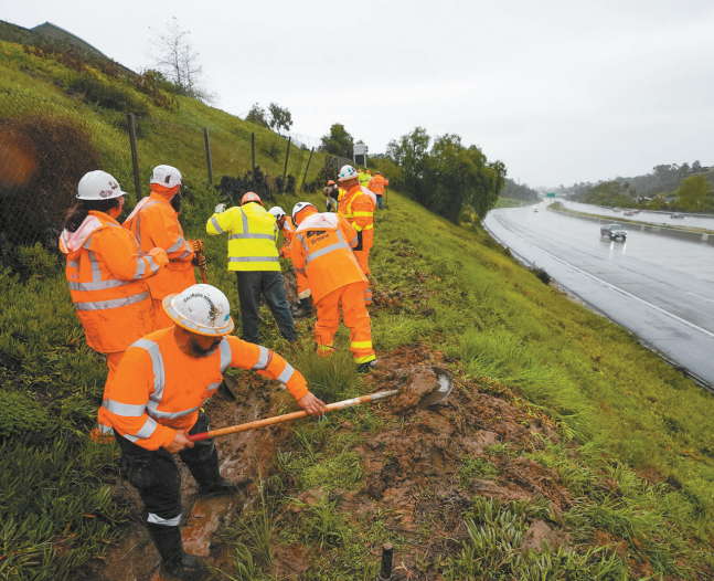 统计显示加州公务员退休人数比去年减少,图为州运输局工作人员今年初雨季期间在公路山坡旁清理防止积水。 统计显示加州公务员退休人数比去年减少,图为州运输局工作人员今年初雨季期间在公路山坡旁清理防止积水。