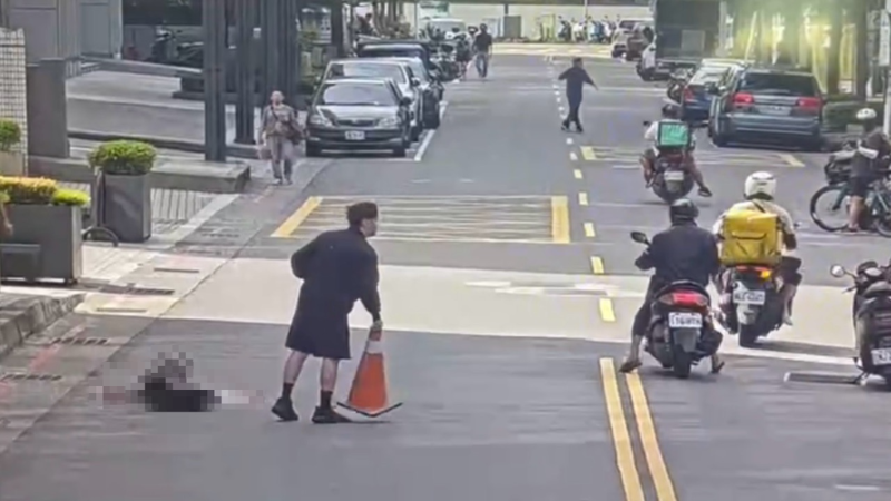 被害人倒卧道路,路人持交通锥协助交维。 被害人倒卧道路,路人持交通锥协助交维。