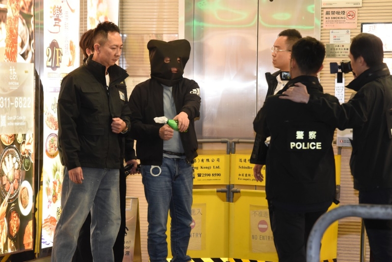 疑犯模拟将汽油弹放在衫袋内,之后到卡拉OK投掷。 疑犯模拟将汽油弹放在衫袋内,之后到卡拉OK投掷。