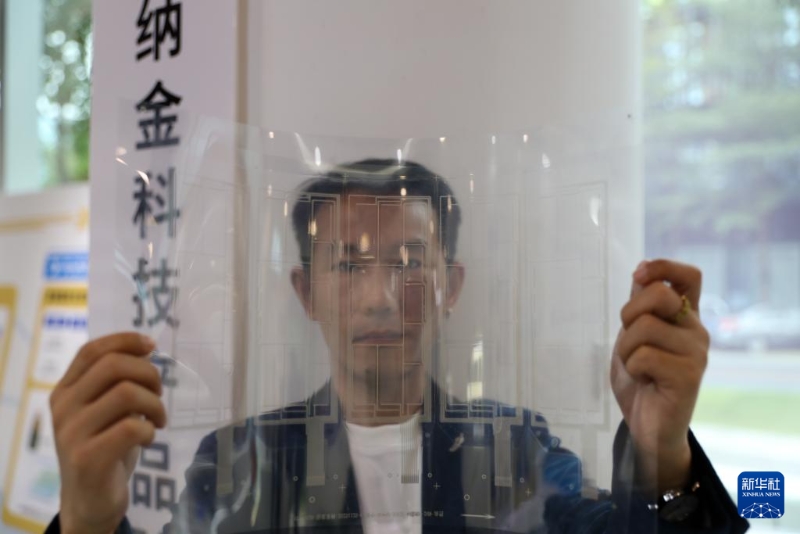 11月25日，在横琴澳门青年创业谷，纳金科技有限公司工作人员展示一张柔性透明导电材料。新华社记者 王益亮 摄