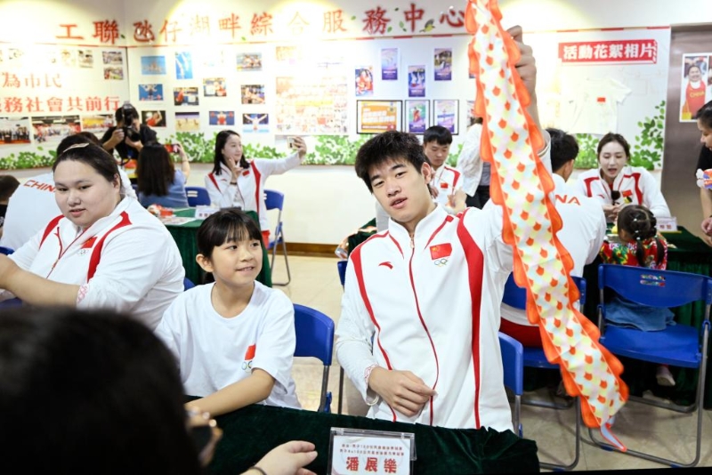 9月2日，在澳门工联氹仔湖畔综合服务中心，游泳运动员潘展乐（右）展示与小朋友一起制作的灯笼。新华社发