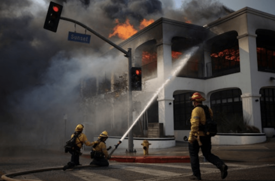 美国加州洛杉矶,一名消防员用水管灭火。路透社 美国加州洛杉矶,一名消防员用水管灭火。路透社