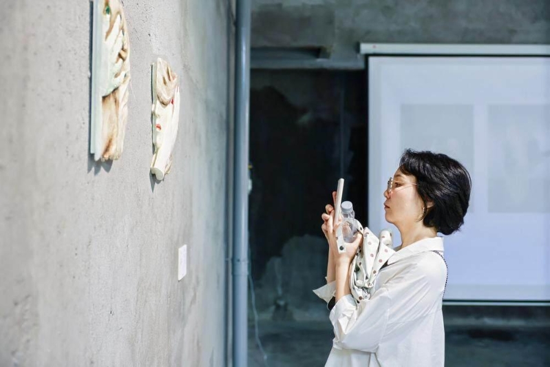 Visitors taking photos of ceramic artworks in the Meitaowan No. 7 Ceramic Warehouse.