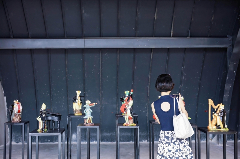 Tourists taking photos of Shiwan ceramic artworks.