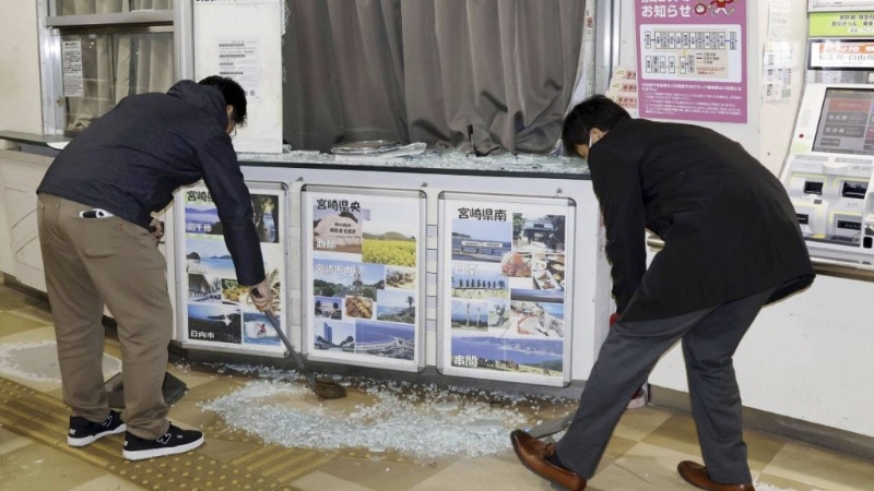 地震发生后，民众清理地面碎玻璃。