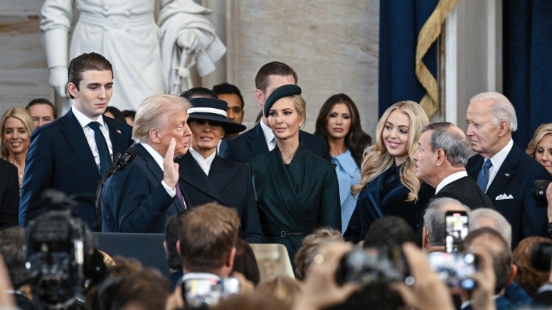 巴伦（左一）越过人群，特地踏前一步，与拜登（右一）和哈里斯扫手。 美联社