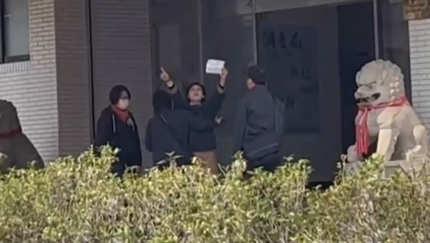 林岱桦与干员在南机站门口爆拉扯，一高举标语激动喊“政治、司法干预初选”遭阻挡。