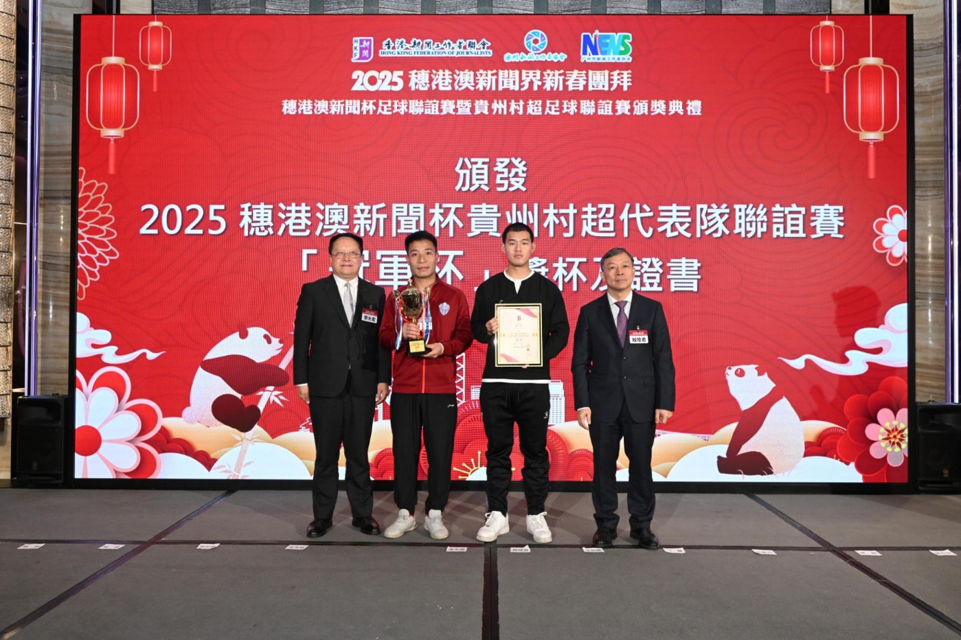 全国政协委员、香港大公文汇传媒集团董事长、香港新闻工作者联会主席李大宏(左)和中华全国新闻工作者协会党组成员、书记处书记 殷陆君(右)为获得港澳新闻杯贵州村超代表队联谊赛冠军杯的贵州村超队颁奖 全国政协委员、香港大公文汇传媒集团董事长、香港新闻工作者联会主席李大宏(左)和中华全国新闻工作者协会党组成员、书记处书记 殷陆君(右)为获得港澳新闻杯贵州村超代表队联谊赛冠军杯的贵州村超队颁奖
