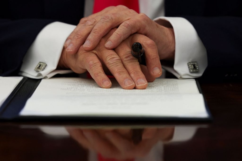 美国总统川普于2025年2月25日在白宫椭圆办公室签署行政命令当天,双手合十。(图/路透) 美国总统川普于2025年2月25日在白宫椭圆办公室签署行政命令当天,双手合十。(图/路透)