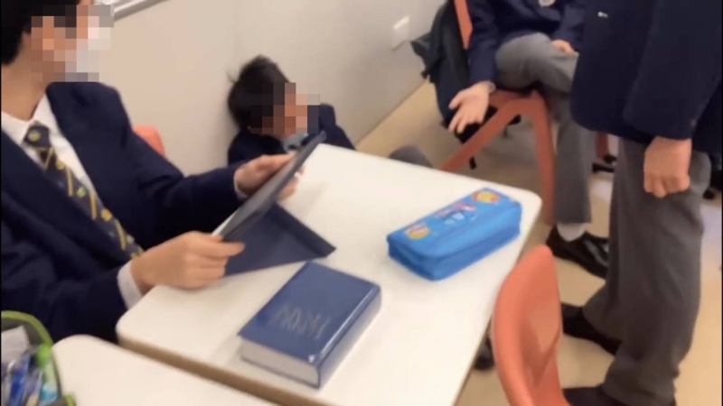 被袭学生瑟缩地上。