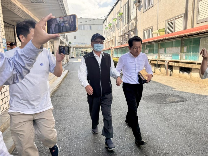 县府明政处长明良臻（右）50万元交保，父亲搀扶步出法院。