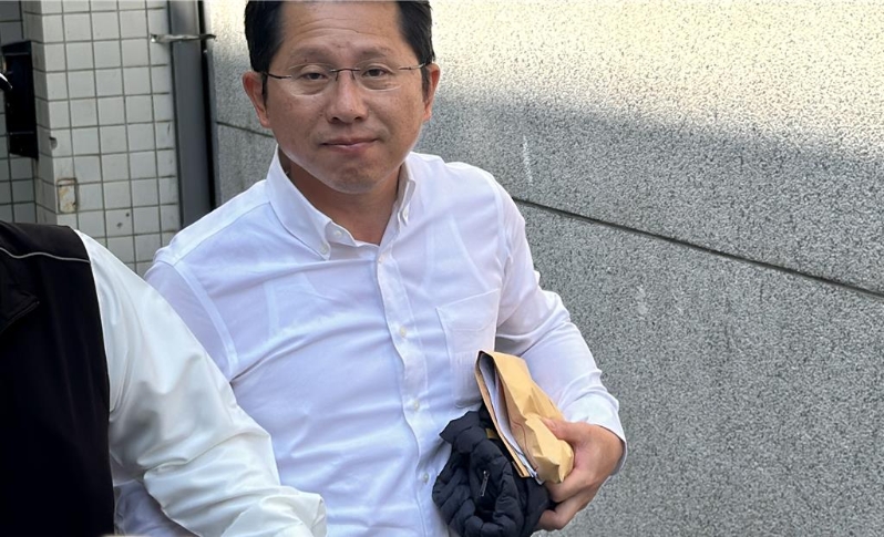 明良臻下午步出法院，面露疲惫、神情苦笑。