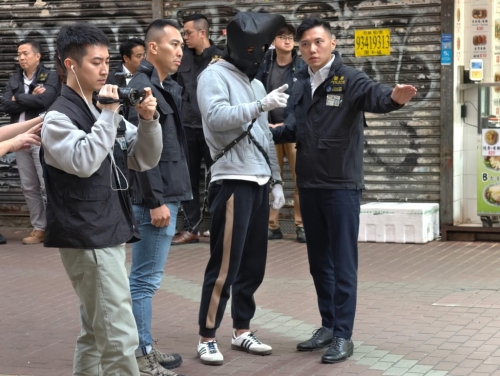 疑犯抵达旺角建兴大厦对开后，回答探员的提问。