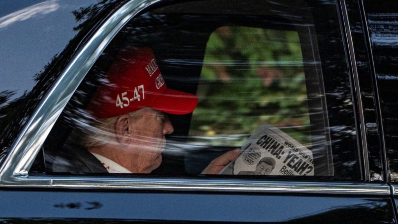 特朗普抵达高球场时,在车上看《纽约邮报》。 美联社 特朗普抵达高球场时,在车上看《纽约邮报》。 美联社