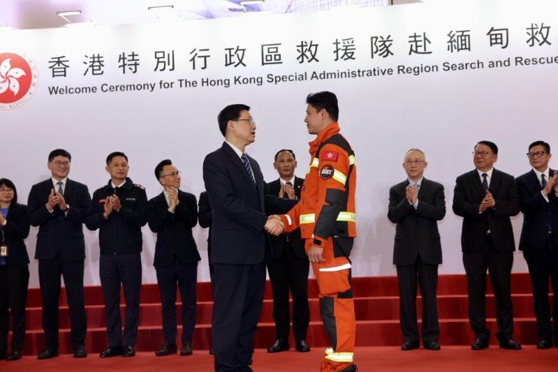 李家超与救援队队员握手。