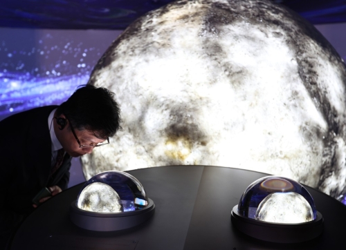 游客在大阪世博中国馆观看月壤。新华社