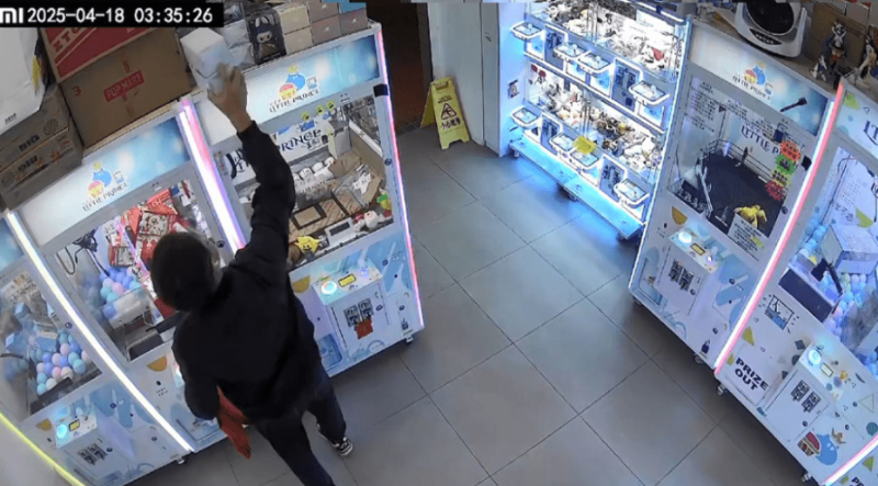 男子在其中一部夾公仔機頂部取下兩盒玩具並放入紙袋。fb「上水，粉嶺，大埔分享群」片段截圖